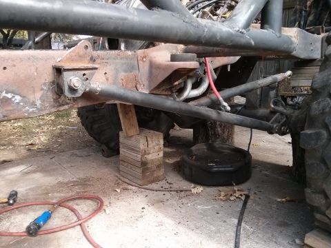 1986 Ford Bronco - Close-up view of a vehicle's undercarriage, showing suspension parts and a frame.