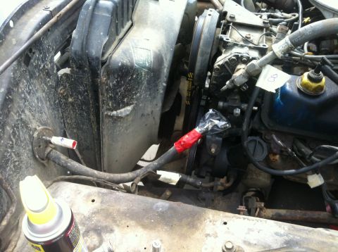 1979 Ford Bronco - Close-up of an engine bay, focusing on the air conditioning compressor and associated plumbing.