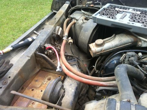 1979 Ford Bronco - Close-up view of a vehicle's engine bay, showing various components and tools.