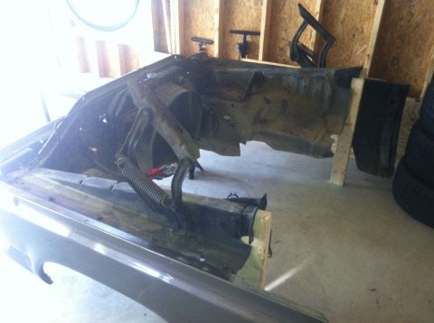 1979 Ford Bronco - The front fender and chassis of a vehicle are visible in a garage setting, possibly undergoing restoration.