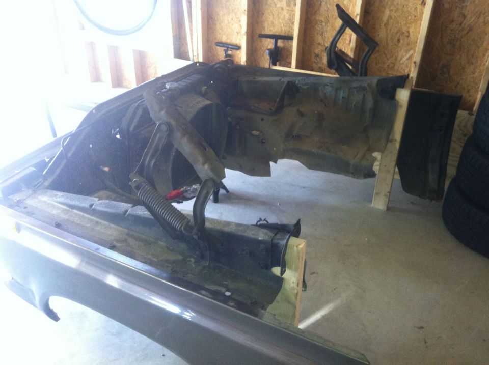Gray front fender and chassis of a vehicle in a garage