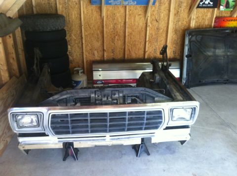 1979 Ford Bronco - Front clip of a 1979 Ford Bronco disassembled and supported by jack stands in a garage.