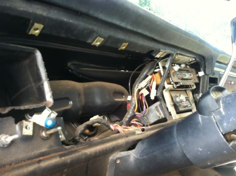 1979 Ford Bronco - The dashboard of a vehicle is disassembled, revealing a complex network of wires and electronic components.