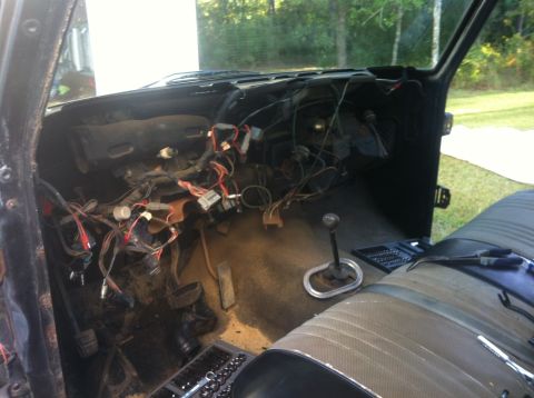 1979 Ford Bronco - Interior of a vehicle undergoing electrical work, with the dashboard disassembled.