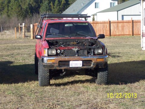 1991 Toyota Pickup/SR5 - Front view of a red 1991 Toyota Pickup/SR5 with its hood open, showing the engine bay.