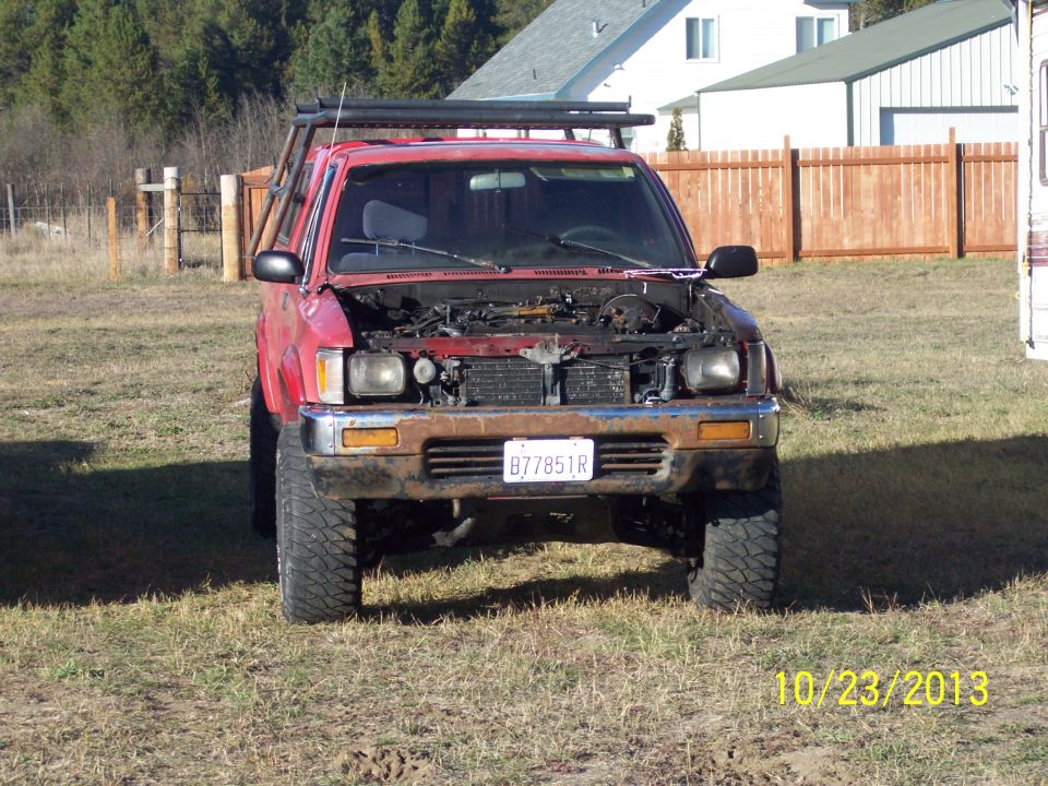 red 1991 Toyota Pickup/SR5, hood up, parked in grassy area