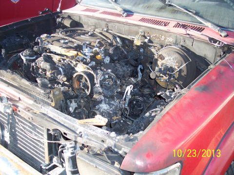1991 Toyota Pickup/SR5 - Vehicle engine bay shows severe fire damage, with melted and charred components visible.