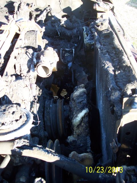 1991 Toyota Pickup/SR5 - The engine bay is heavily damaged by fire, with melted hoses and a charred radiator visible.