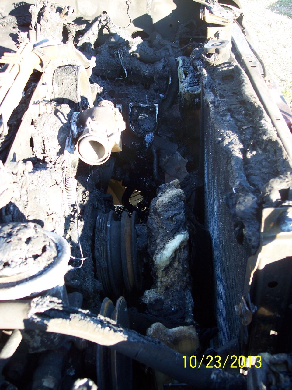 Engine compartment after fire, showing melted and charred components