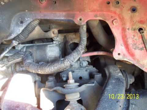 1991 Toyota Pickup/SR5 - Close-up view of engine bay components, including a starter motor and various hoses, with a red painted frame.