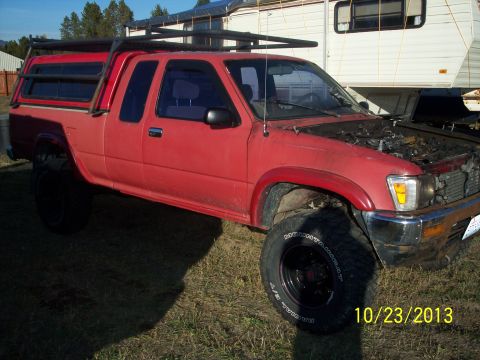 1991 Toyota Pickup/SR5 - This 1991 Toyota Pickup is parked outdoors with its hood up, showing the engine bay.