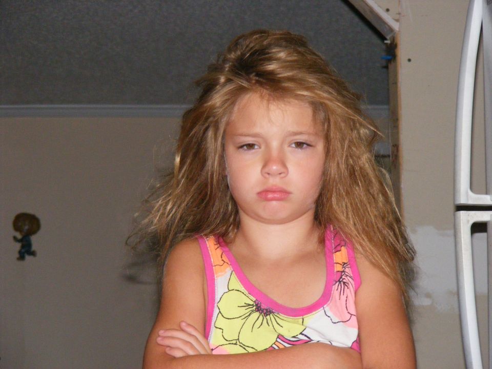 Young girl with arms crossed and a pouty expression