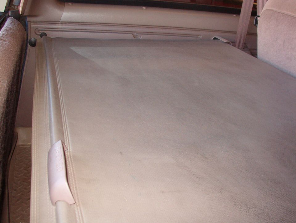 Factory Bronco cargo cover fully extended.  Factory cargo net missing.  Aftermarket cargo tray visible.