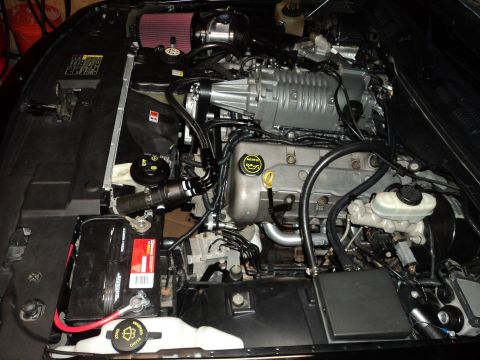2004 Mercury Grand Marquis - Engine bay features a silver supercharger and red air filter, indicating performance modifications.
