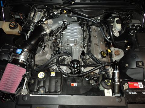 2004 Mercury Grand Marquis - Close-up view of a modified V8 engine a prominent supercharger and aftermarket air intake system.