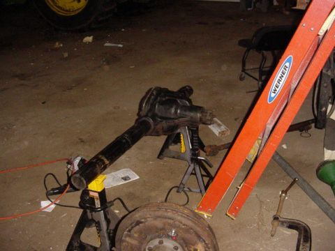 1992 Ford Bronco - A front axle assembly is supported by jack stands in a garage setting.