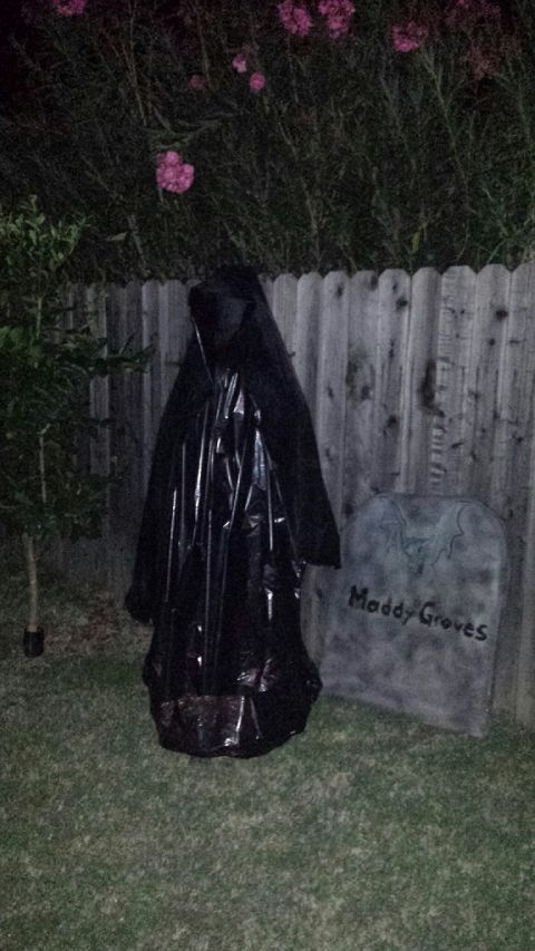 1989 Ford Bronco - A spooky Halloween decoration a grim reaper figure and a tombstone sits in a yard at night.