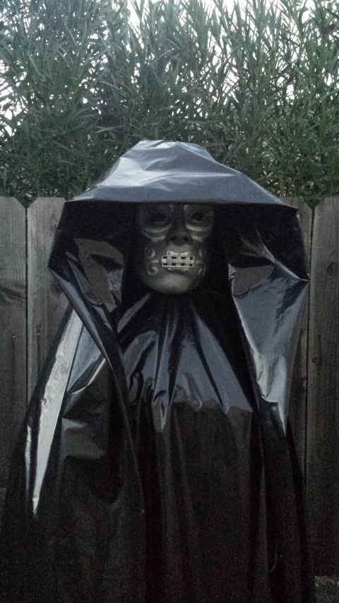 1989 Ford Bronco - A figure in a dark cloak and mask stands outdoors, resembling a character from the Harry Potter series.
