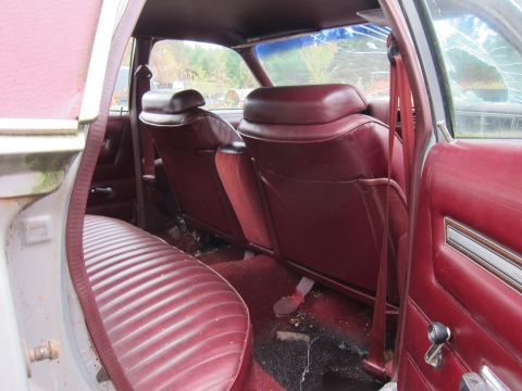 1991 Ford LTD Crown Victoria - Maroon interior of a car, showing the rear seats and door panel.