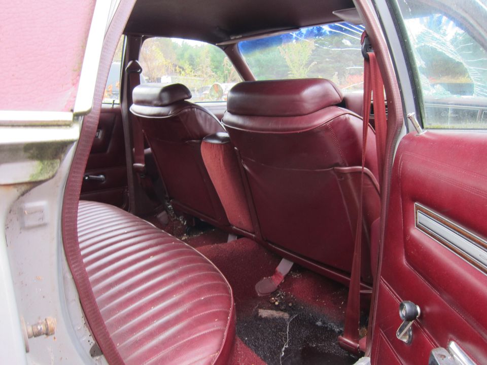 Interior view of a car with maroon seats and cracked rear window