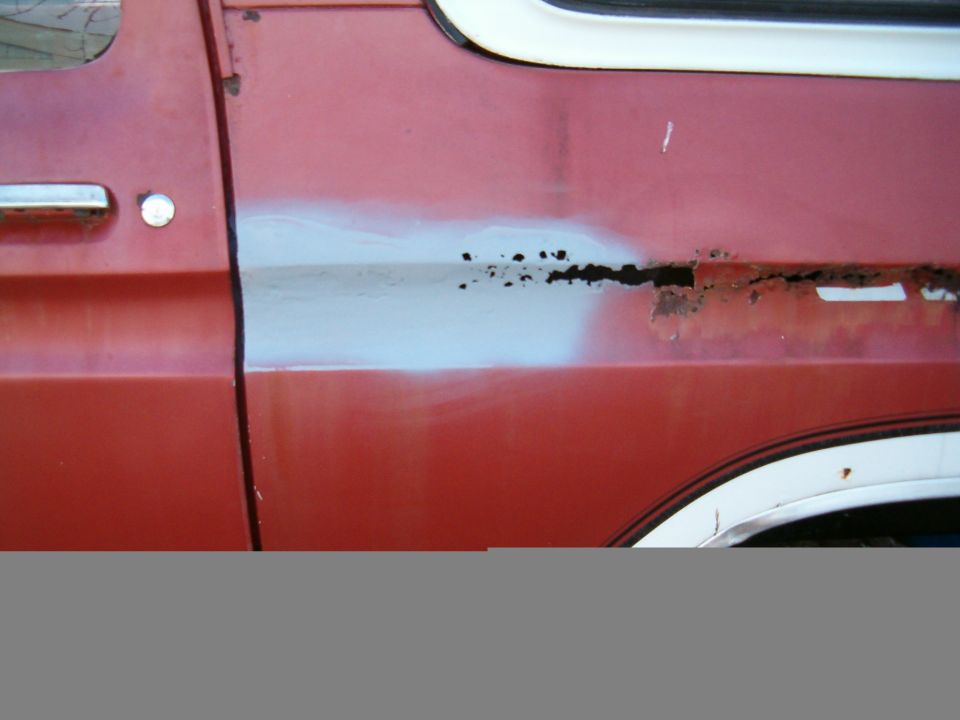 1979 Ford Bronco side door showing rust damage and primer repair