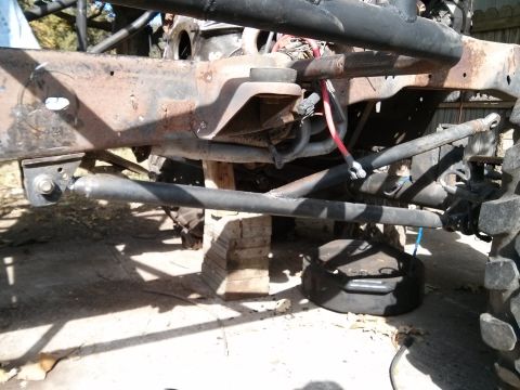 1986 Ford Bronco - The underside of a vehicle, showing its frame and suspension system, is elevated on blocks.