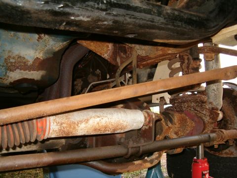 1979 Ford Bronco - This photo shows the heavily rusted undercarriage of a vehicle, focusing on suspension and exhaust parts.