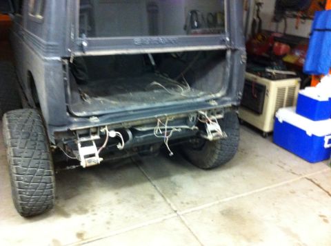 1987 Suzuki Samurai - Rear view of a 1987 Suzuki Samurai with the bumper removed, revealing the frame and wiring.