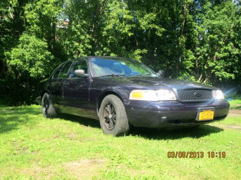 2003 Ford Crown Victoria - Dark 2003 Ford Crown Victoria parked on a grassy area with trees in the background. Date stamp shows 03/08/2013.