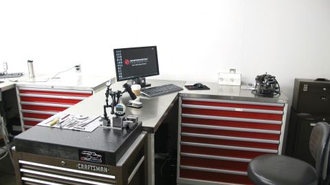 1996 Ford Bronco - A workbench setup with precision measuring tools and a computer workstation.