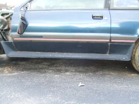 1996 Ford Bronco - Side view of a blue car's door and fender, showing trim detail.