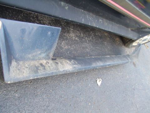 1996 Ford Bronco - Side view of a vehicle's lower body panel and tire, showing dirt and wear.