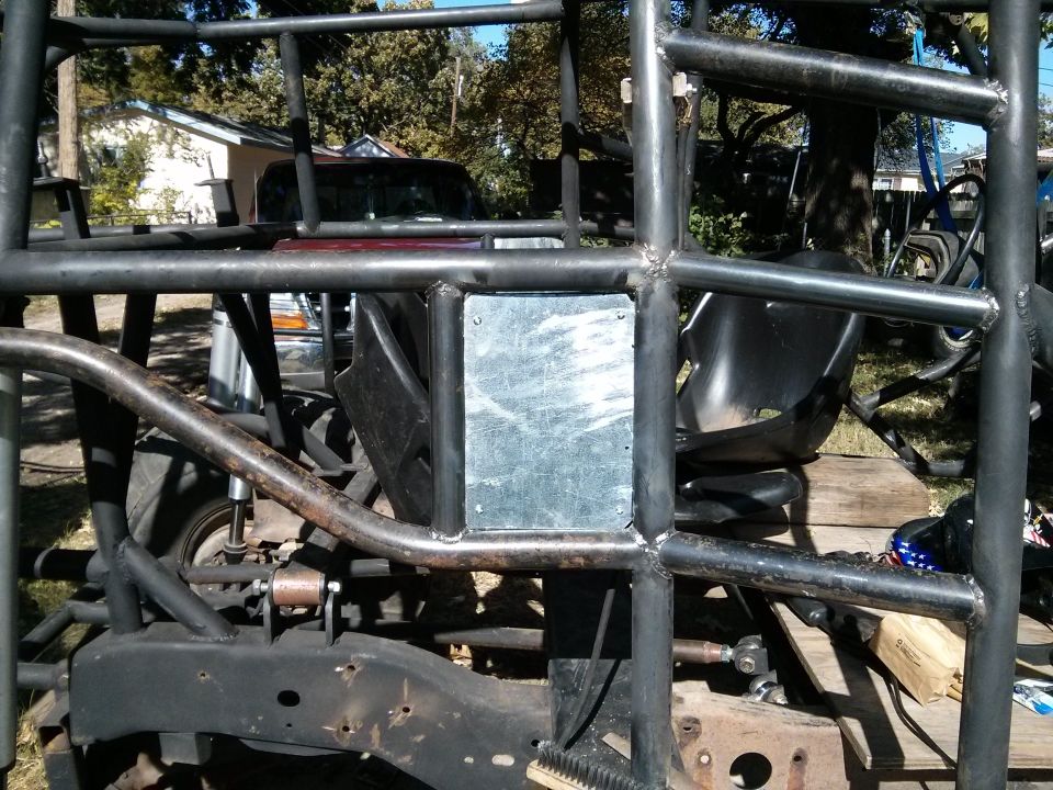 Custom roll cage structure over vehicle frame and parts of a maroon truck