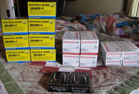 1992 Ford Bronco - Various boxes of ammunition are arranged on a bed with a patterned blanket.