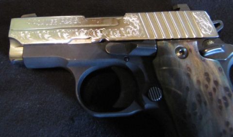 1992 Ford Bronco - This pistol features intricate scrollwork on its slide and a unique, speckled grip pattern.