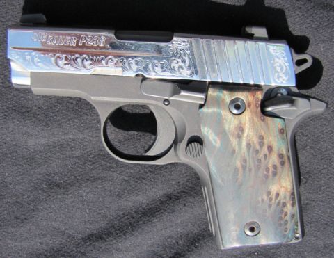1992 Ford Bronco - A close-up view of a SIG Sauer P238 pistol, noted for its decorative slide and unique grip panels.