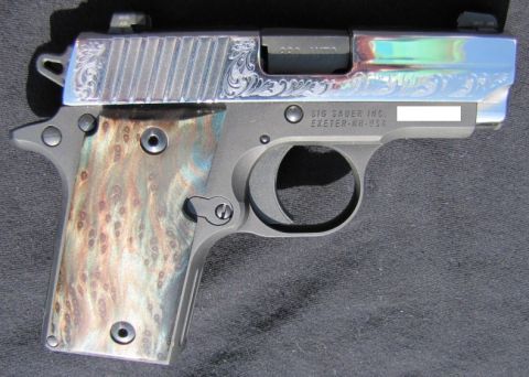 1992 Ford Bronco - Sig Sauer P238 pistol features intricate engraving on the slide and unique wood grips.