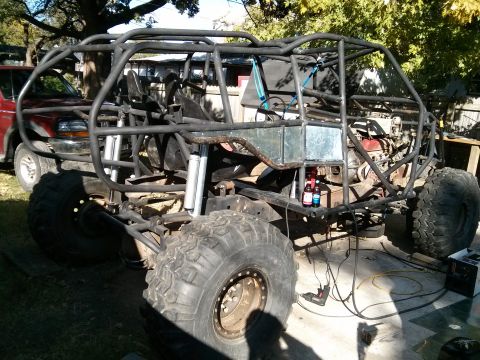 1986 Ford Bronco - This custom-built off-road buggy frame is under construction, with a red truck visible in the background.