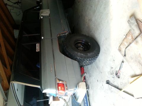 1982 Jeep Wagoneer - Side view of a 1982 Jeep Wagoneer, possibly undergoing maintenance in a garage.