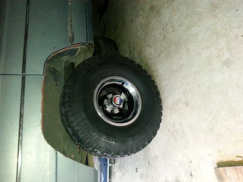 1982 Jeep Wagoneer - A close-up of a Jeep wheel and fender shows a red, white, and blue badge on the hub.