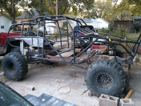 1986 Ford Bronco - This custom-built buggy is undergoing a significant modification with a prominent roll cage and oversized tires.