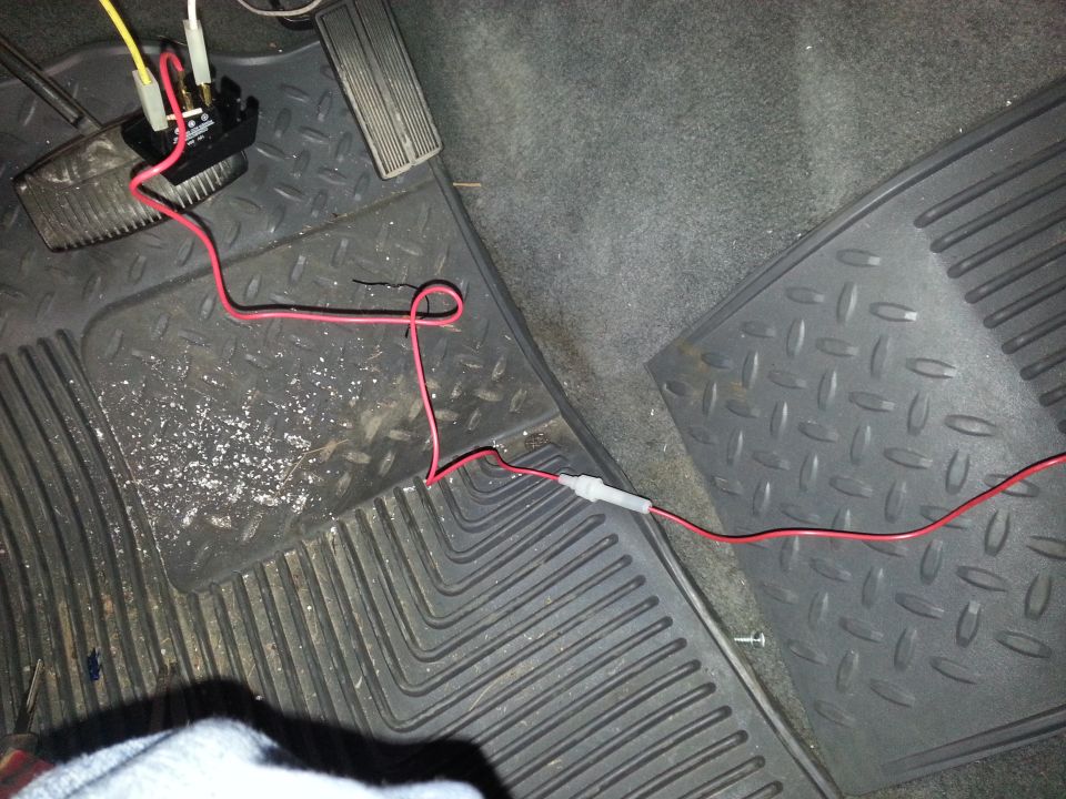 aftermarket wiring harness connected to a black box near the pedals
