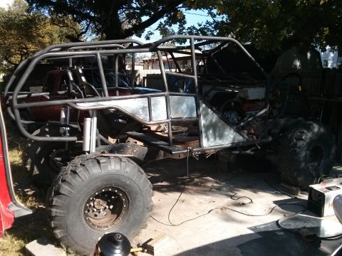 1986 Ford Bronco - This heavily modified vehicle is undergoing construction, a custom roll cage and large off-road tires.