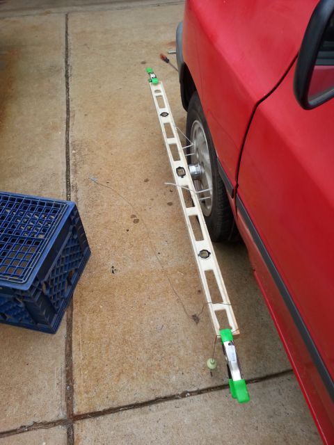 1991 Ford Festiva - A red car's side is visible with a measuring tool attached to the wheel.