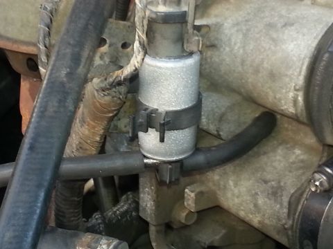 1994 Ford Bronco - Photograph of an engine-mounted canister and hose, not a technical document.