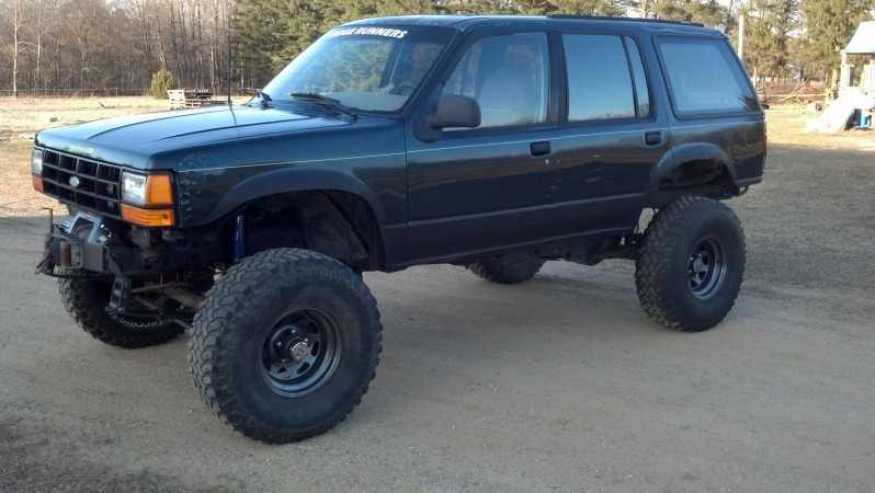 Lifted dark green 1993 Ford Explorer SUV with off-road tires and winch
