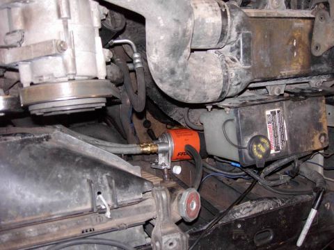 1980 Ford Bronco - Close-up view of an engine bay, highlighting an orange oil filter and a black reservoir with a Motorcraft label.