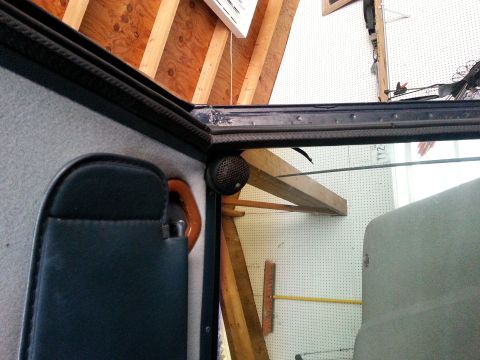 1982 Jeep Wagoneer - Interior view of a vehicle's corner, showing a speaker mounted near the roofline and a portion of a dark-colored sun visor.