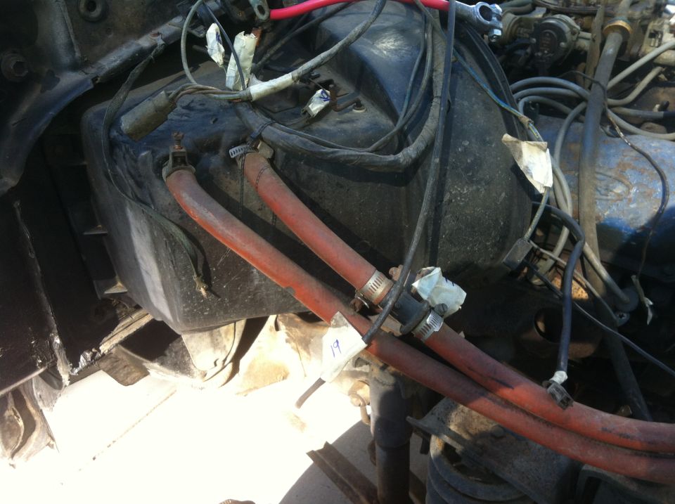 1979 Ford Bronco engine bay with heater core hoses and wiring