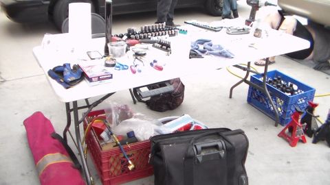2003 Ford Crown Victoria - Photograph of automotive tools, sockets and jack stands spread on a folding table, not a technical document.